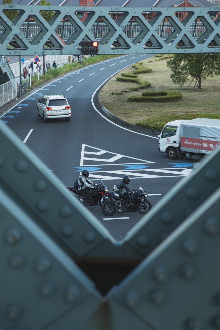 vehicles driving on asphalt road in city